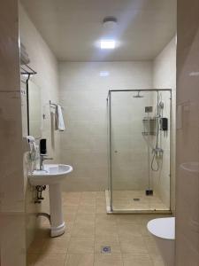 een badkamer met een glazen douche en een wastafel bij Moon hotel in Yakkasaray +21 foto's