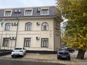 een gebouw met twee auto's ervoor geparkeerd bij Moon hotel in Yakkasaray
