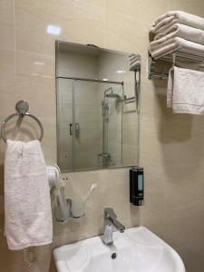een badkamer met een wastafel en een spiegel bij Moon hotel in Yakkasaray