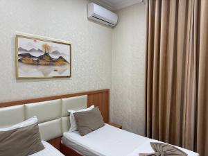 een hotelkamer met 2 bedden en een gordijn bij Moon hotel in Yakkasaray