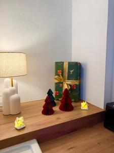 Una habitación con una mesa con lámpara y regalos. en Evasion T2 avec terrasse, en Saint-Didier-sur-Chalaronne