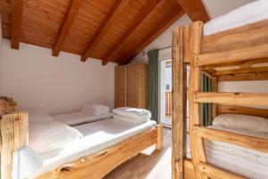 2 stapelbedden in een kamer met houten plafonds bij Hapina Dolomiti in Cencenighe