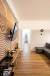 una sala de estar con un sofá y un televisor en GetTheKey Marconi Apartments, en Bolonia
