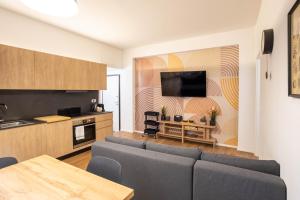 Una sala de estar con un sofá y una cocina. en GetTheKey Marconi Apartments, en Bolonia