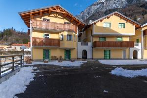 een huis in de bergen met sneeuw op de grond bij Hapina Dolomiti in Cencenighe