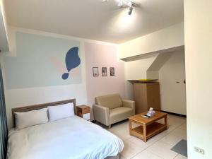 a small bedroom with a bed and a chair at 暖かさ城宿 in Taichung