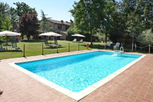 a swimming pool with blue water in a yard at La Cerretola in Città della Pieve