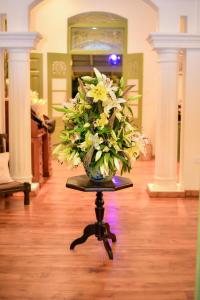 a vase of flowers on a table in a room at Ridee Kandy in Kandy