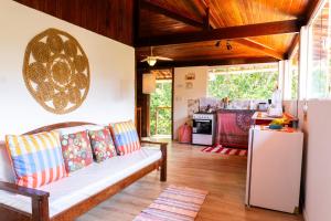 a living room with a couch and a kitchen at Pipa Surf Yoga Apartamento e Suítes com cozinha completa in Pipa