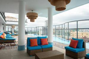 a hotel lobby with blue chairs and a swimming pool at Kingfisher Nest Hotel Suites- Westlands, Near Sarit Center in Nairobi