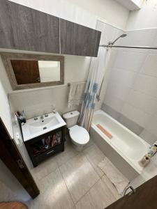 Un baño con lavabo, inodoro y bañera. en Casa con Patio y Parrilla Zona Golf, en Villa Gesell