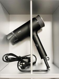 a black blow dryer sitting on a shelf at 엠지스테이 서면 Mzstay Modern Hotel in Seomyeon in Busan