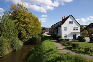 a white house on the side of a river at WeLiving Apartments in Weinheim