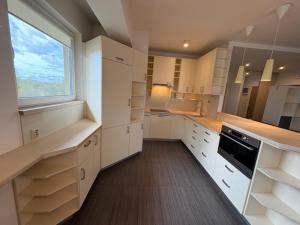 a large kitchen with white cabinets and a window at Apartament przy szpitalu CZMP Łódź in Łódź +3 photos