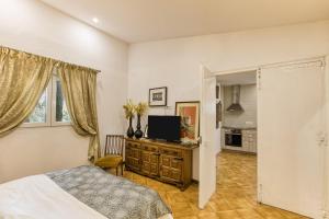Bosque Apartamento في جيرونا: غرفة نوم بها سرير وتلفزيون على خزانة