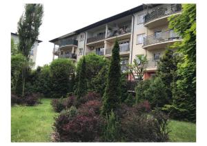an apartment building with a garden in front of it at Apartament przy szpitalu CZMP Łódź in Łódź