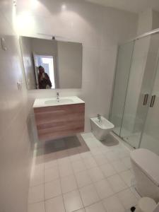 a bathroom with a sink and a toilet and a mirror at Charming Apartment in Malaga - 70 m² with Balcony in Málaga