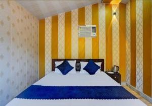 a bedroom with a bed with blue and yellow walls at Valley King Resort in Rishīkesh +21 photos
