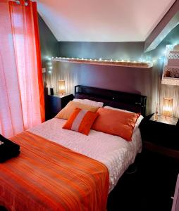 a bedroom with a large bed with orange pillows at Reggae Beach Getaway in Saltdean