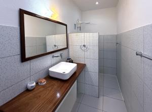 a white bathroom with a sink and a mirror at Pousada Caminho da Praia in Jericoacoara +116 photos