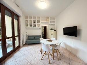 Una sala de estar con una mesa y sillas blancas. en ANADÌA apartment, en Monza