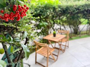 Una mesa y sillas de madera en un patio. en ANADÌA apartment, en Monza