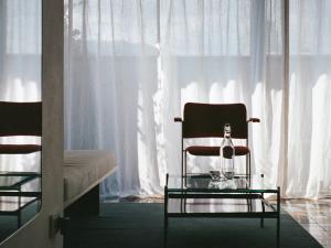 Una silla sentada en una habitación con ventana. en Bellhop Tbilisi, en Tiflis