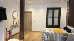 a bedroom with a bed and a mirror and a television at Alojamiento en Ribadesella in Ribadesella