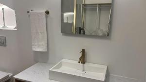 a white bathroom with a sink and a mirror at Alojamiento en Ribadesella in Ribadesella