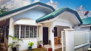 a small white house with a blue roof at Isla Vida Apartments in Bantayan Island