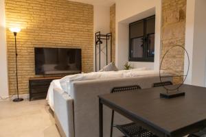 Una sala de estar con un sofá y un televisor. en Apartamentos Baños, 6 CAROLA, en Linares