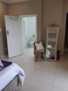 a bedroom with a bed and a bathroom with a mirror at THE VIEW in Port Alfred