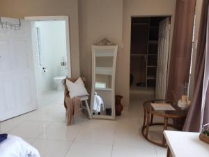 a white bathroom with a chair and a mirror at THE VIEW in Port Alfred +4 photos