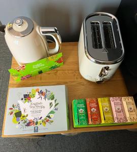a table with a tea kettle and books on it at Reggae Beach Getaway in Saltdean