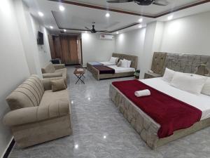 a bedroom with a bed and a living room with a couch at Royel IN Hotel in Mund Pīr Mahmūd