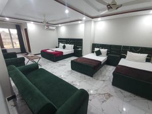 a room with two beds and couches in a room at Royel IN Hotel in Mund Pīr Mahmūd