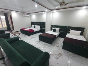 a living room with two beds and a couch at Royel IN Hotel in Mund Pīr Mahmūd