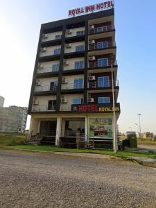 a hotel with a sign on the side of it at Royel IN Hotel in Mund Pīr Mahmūd