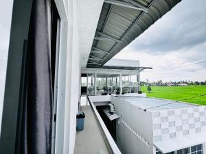 a balcony of a house with a view of a field at Mila Homestay in Padang