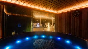 een bad met blauwe verlichting in een kamer bij Villa Delta Boutique in Kościelisko