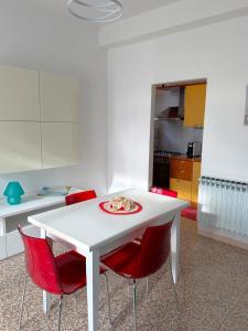 a white table with red chairs in a kitchen at Suite Barni in Barni +9 photos