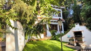 une maison blanche avec un jardin avec une table et un barbecue dans l'établissement Villa Valmores, à Olmeda de las Fuentes