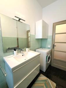 a bathroom with a sink and a washing machine at Suite Barni in Barni