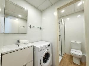 a white bathroom with a washing machine and a toilet at DOMuum Holidays - DELFOS in Salou