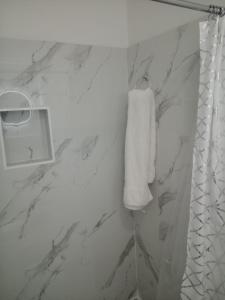 een badkamer met een witte handdoek aan de muur bij E&C short term rental in Nassau
