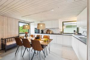 Feriehus 1140 في سوندرفيغ: مطبخ وغرفة طعام مع طاولة وكراسي
