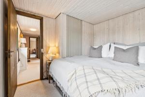 Feriehus 1140 في سوندرفيغ: غرفة نوم بها سرير أبيض كبير في الغرفة