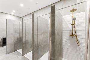 Porto Hostel Cúpula في بورتو: دش للمشي في حمام بجدران رمادية