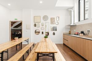 a kitchen with two wooden tables and a counter at Porto Hostel Cúpula in Porto
