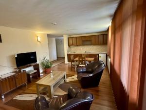 a living room with leather chairs and a table at Семеен Хотел Ажур in Kotel